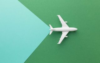 top-view-white-plane-on-green-background-1-scaled